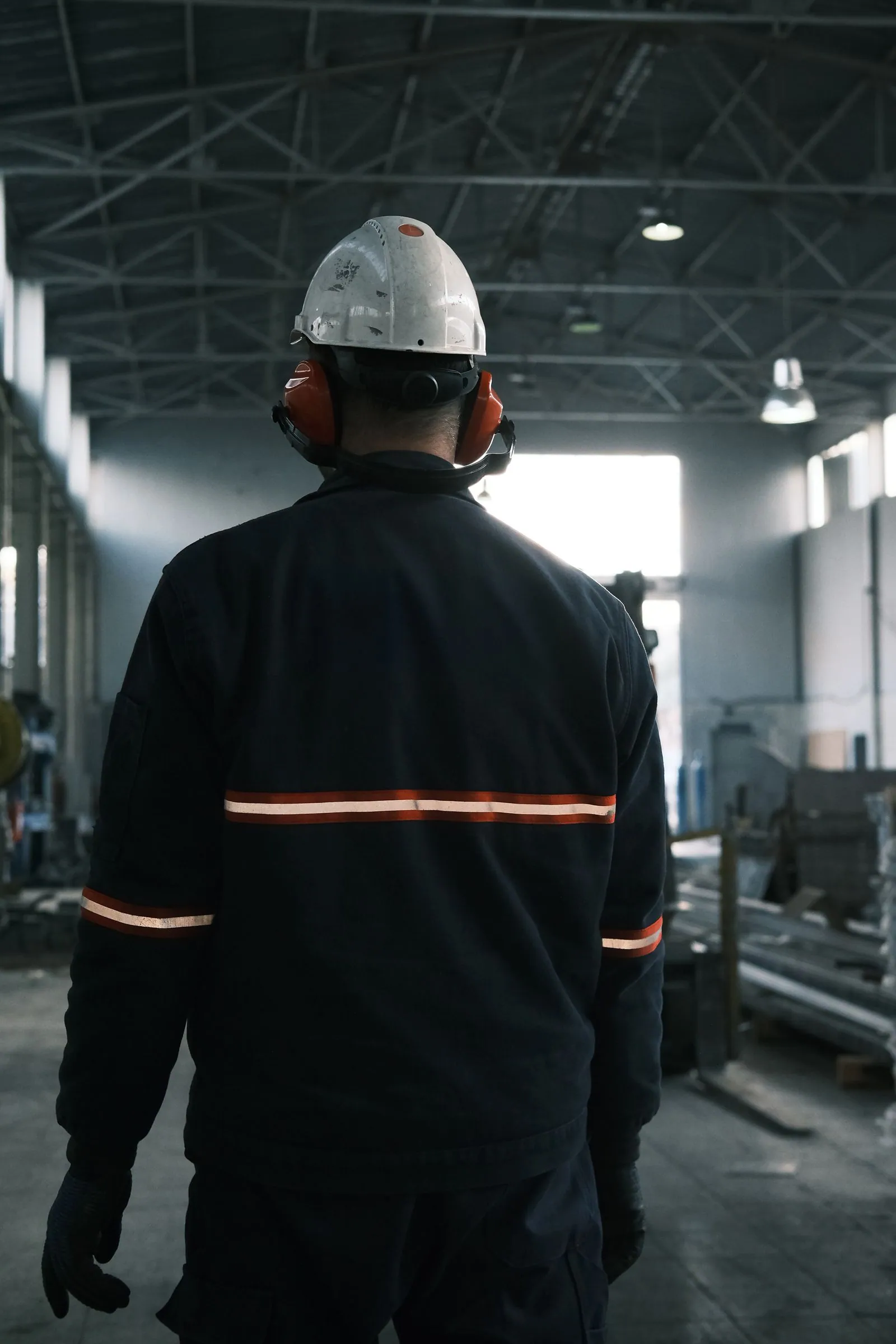 Mitarbeiter mit Schutzhelm in einer Produktionshalle